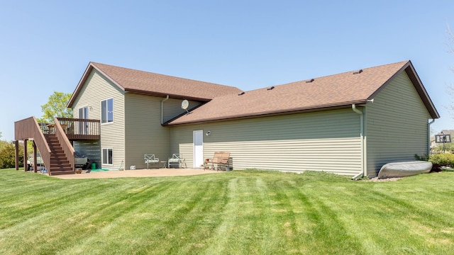 rear view of house featuring a deck, stairway, a yard, a patio area, and a shingled roof