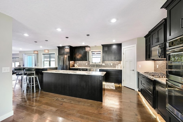 14590 Thicket Ln, Dayton, MN 55327 - kitchen with appliances with stainless steel finishes, healthy amount of natural light, a spacious island, dark wood finished floors, and recessed lighting