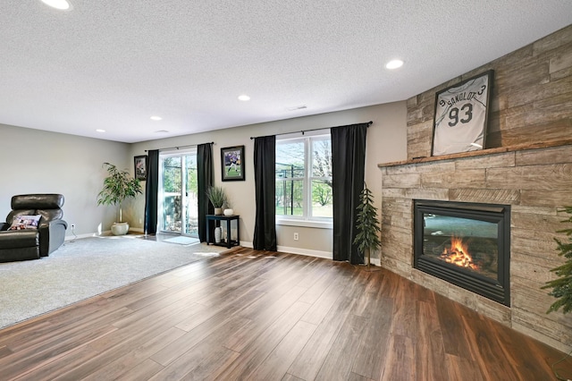 14590 Thicket Ln, Dayton, MN 55327 - unfurnished living room with a large fireplace, a textured ceiling, baseboards, wood finished floors, and recessed lighting