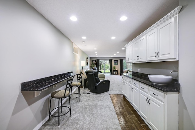 14590 Thicket Ln, Dayton, MN 55327 - kitchen featuring recessed lighting, dark carpet, white cabinets, a kitchen breakfast bar, and open floor plan
