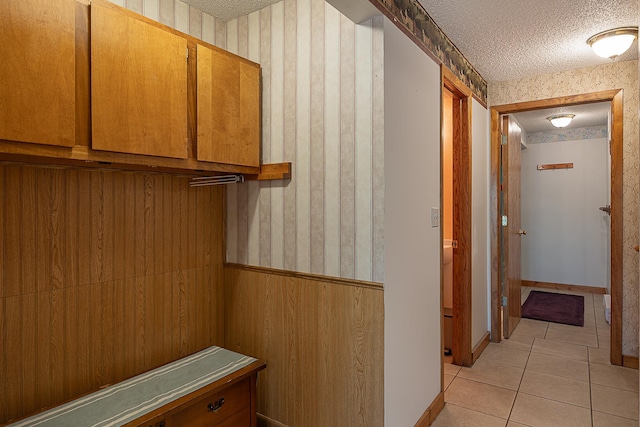 5305 Cisco Ln NE, Remer, MN 56672 - hallway featuring a textured ceiling, wallpapered walls, light tile patterned flooring, and baseboards