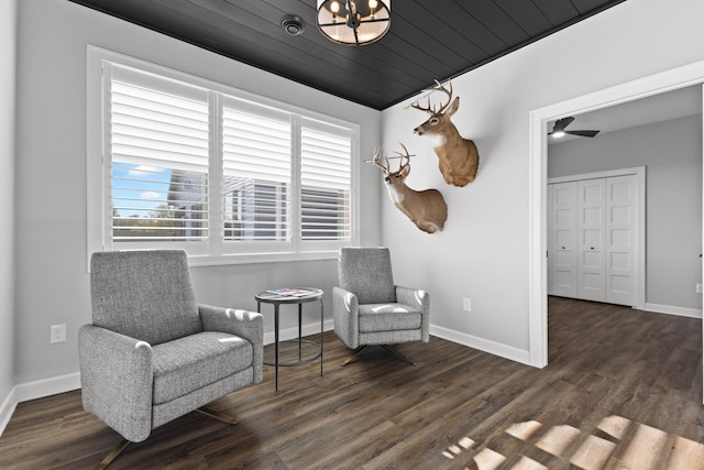 living area featuring baseboards, dark wood-style floors, and a chandelier