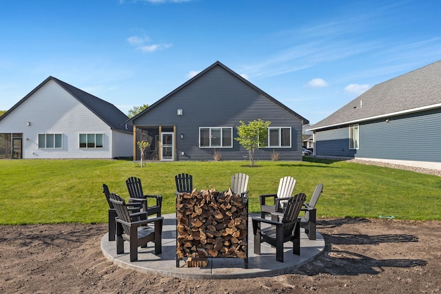 back of house with a fire pit and a yard