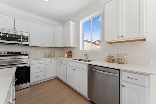 7478 170th Ave NW, Ramsey, MN 55303 - kitchen with appliances with stainless steel finishes, a sink, light wood-type flooring, and white cabinetry