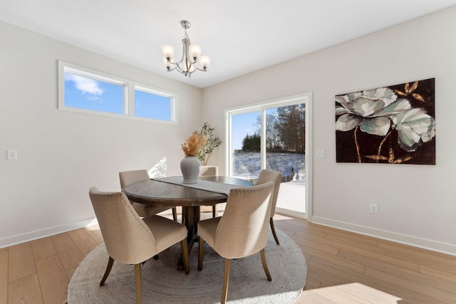 7478 170th Ave NW, Ramsey, MN 55303 - dining area featuring a chandelier, baseboards, and light wood-style flooring