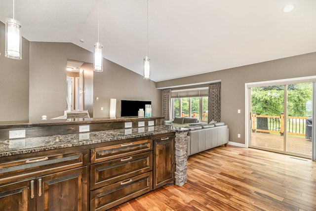 1270 145th Ave NW, Andover, MN 55304 - kitchen with open floor plan, vaulted ceiling, light wood-style flooring, dark brown cabinetry, and dark stone counters