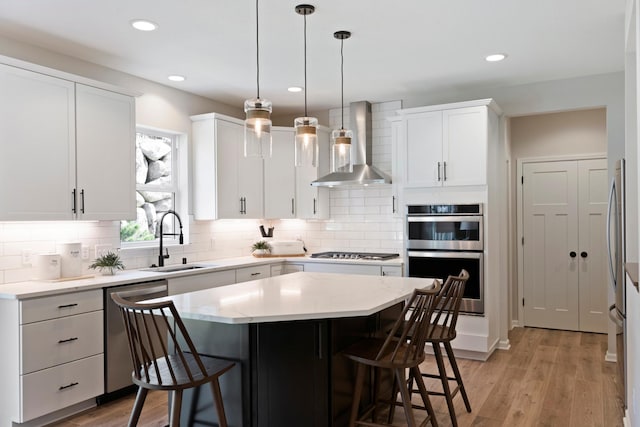 19554 105th Ave, Corcoran, MN 55374 - kitchen with wall chimney range hood, a sink, stainless steel appliances, a kitchen bar, and light wood finished floors