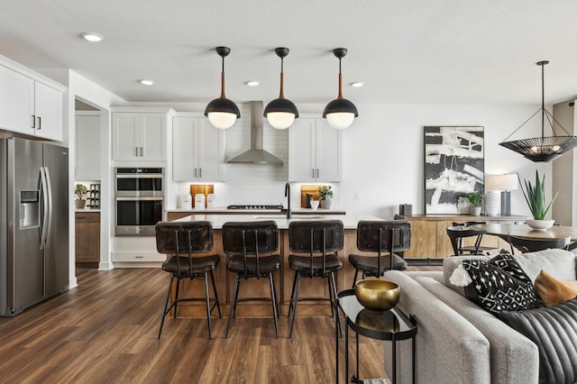 19649 105th Ave, Corcoran, MN 55374 - kitchen featuring stainless steel appliances, wall chimney range hood, open floor plan, dark wood-type flooring, and tasteful backsplash