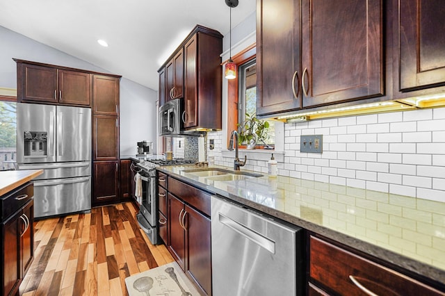 8132 Fillmore St NE, Spring Lake Park, MN 55432 - kitchen with stainless steel appliances, a sink, wood finished floors, light stone countertops, and backsplash