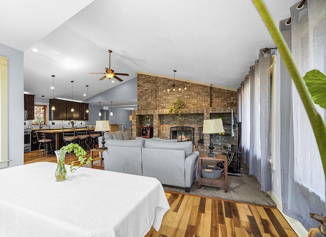 8132 Fillmore St NE, Spring Lake Park, MN 55432 - dining room with light wood finished floors, lofted ceiling, ceiling fan, brick wall, and a fireplace
