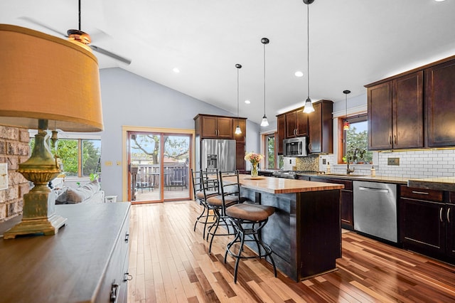 8132 Fillmore St NE, Spring Lake Park, MN 55432 - kitchen featuring stainless steel appliances, a breakfast bar area, dark brown cabinetry, backsplash, and pendant lighting