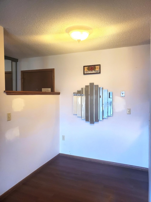 8935 Old Cedar Ave S Unit 113, Bloomington, MN 55425 - spare room with wood finished floors, a textured ceiling, and baseboards