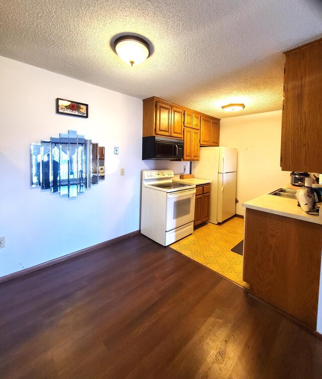 8935 Old Cedar Ave S Unit 113, Bloomington, MN 55425 - kitchen with white appliances, light wood-style flooring, brown cabinetry, a textured ceiling, and baseboards