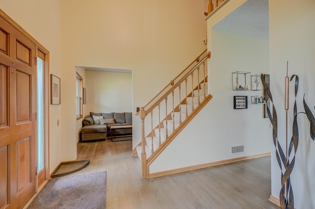 2167 Woodbridge Way, Woodbury, MN 55125 - entryway featuring wood finished floors, a towering ceiling, stairway, healthy amount of natural light, and baseboards