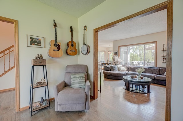 2167 Woodbridge Way, Woodbury, MN 55125 - living area featuring wood finished floors, stairway, baseboards, and a textured ceiling