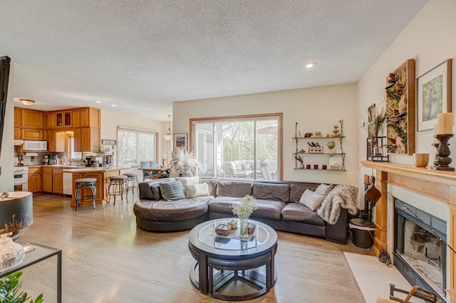 2167 Woodbridge Way, Woodbury, MN 55125 - living room with a textured ceiling, light wood finished floors, a fireplace, and recessed lighting