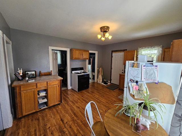 kitchen with tile countertops, range with gas cooktop, brown cabinets, dark wood finished floors, and a chandelier