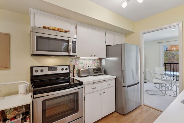 3412 Oak Ridge Rd Unit 317, Minnetonka, MN 55305 - kitchen featuring appliances with stainless steel finishes, light wood-style flooring, light countertops, and white cabinetry
