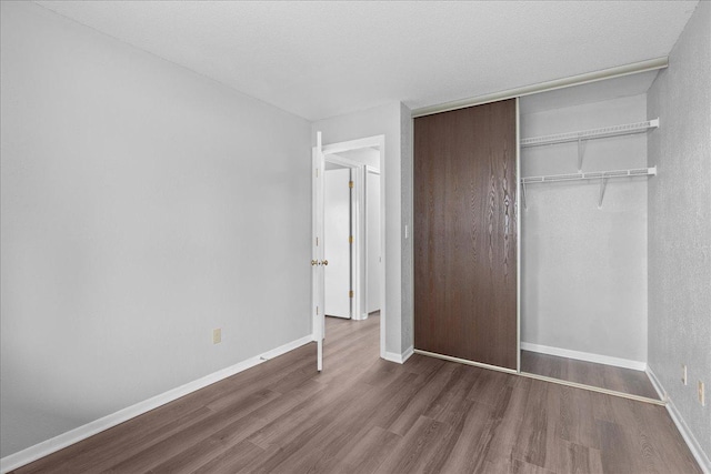 3440 Golfview Dr Unit 123, Eagan, MN 55123 - unfurnished bedroom with wood finished floors, a closet, and baseboards