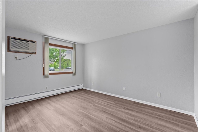 3440 Golfview Dr Unit 123, Eagan, MN 55123 - empty room with baseboard heating, a wall mounted air conditioner, wood finished floors, a textured ceiling, and baseboards