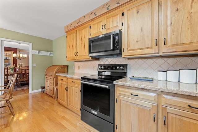 kitchen with stainless steel electric range oven, light brown cabinets, a chandelier, and tasteful backsplash