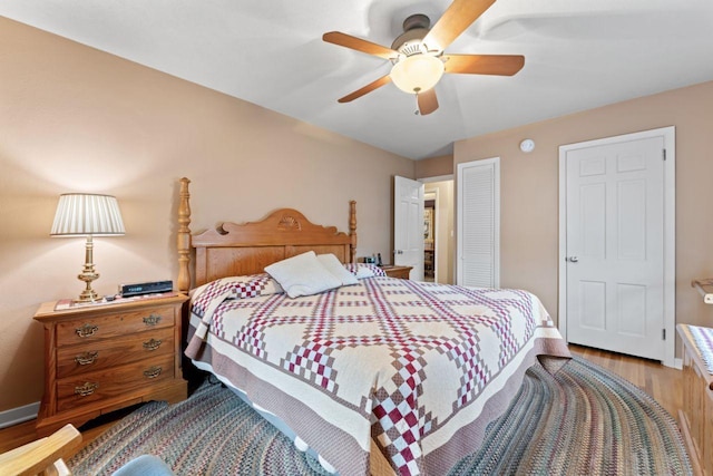 bedroom featuring wood finished floors, baseboards, and ceiling fan