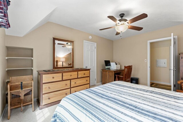 bedroom with an office area, a ceiling fan, and baseboards