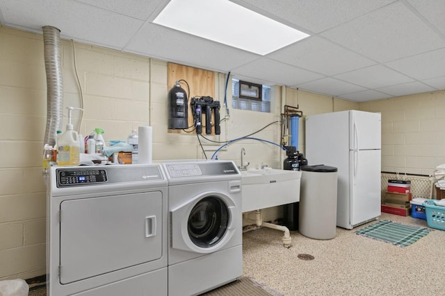 washroom featuring washer and dryer and concrete block wall