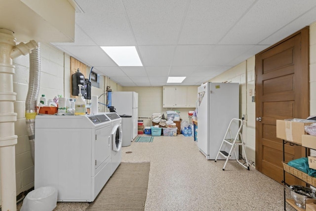 washroom featuring washer and clothes dryer and concrete block wall