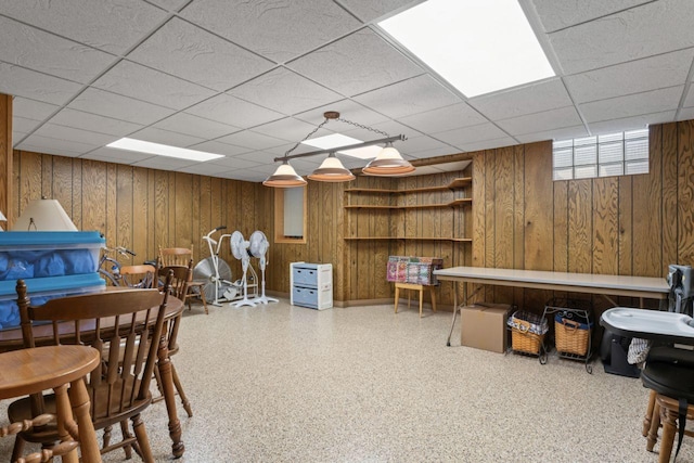 recreation room with wood walls and a paneled ceiling