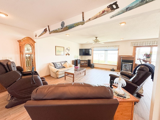 49262 Big Pine Rd, Perham, MN 56573 - living area with light wood-type flooring, a glass covered fireplace, and ceiling fan