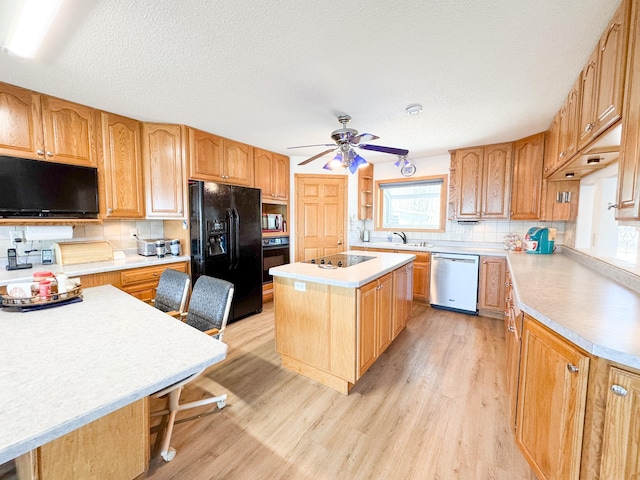 49262 Big Pine Rd, Perham, MN 56573 - kitchen featuring black appliances, healthy amount of natural light, light wood-style flooring, and a kitchen island