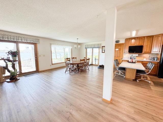49262 Big Pine Rd, Perham, MN 56573 - dining area featuring a textured ceiling, light wood-style floors, baseboards, and a chandelier