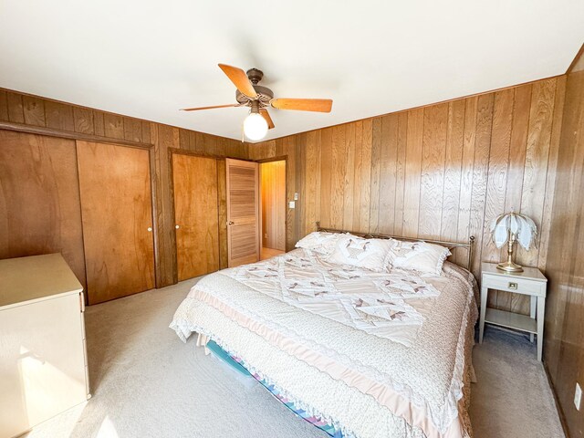 49262 Big Pine Rd, Perham, MN 56573 - bedroom with light colored carpet, wood walls, multiple closets, and ceiling fan
