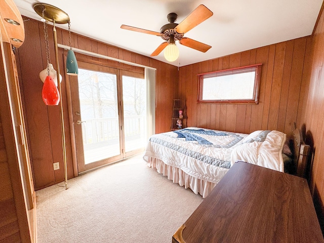 49262 Big Pine Rd, Perham, MN 56573 - bedroom featuring access to exterior, carpet floors, wood walls, and a ceiling fan