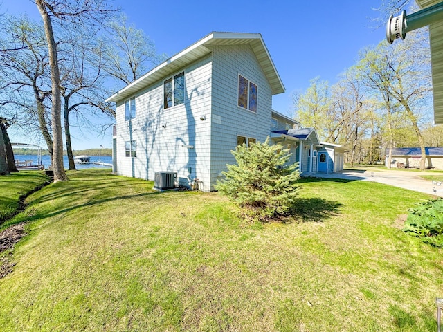 49262 Big Pine Rd, Perham, MN 56573 - view of side of home with a water view, cooling unit, a yard, and concrete driveway