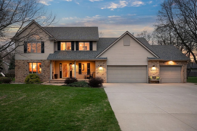 view of front of house with a porch, an attached garage, concrete driveway, brick siding, and a yard