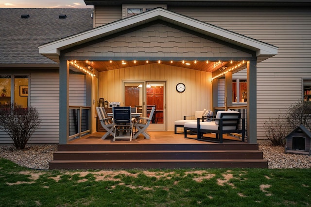rear view of house featuring outdoor dining area, a deck, and a lawn