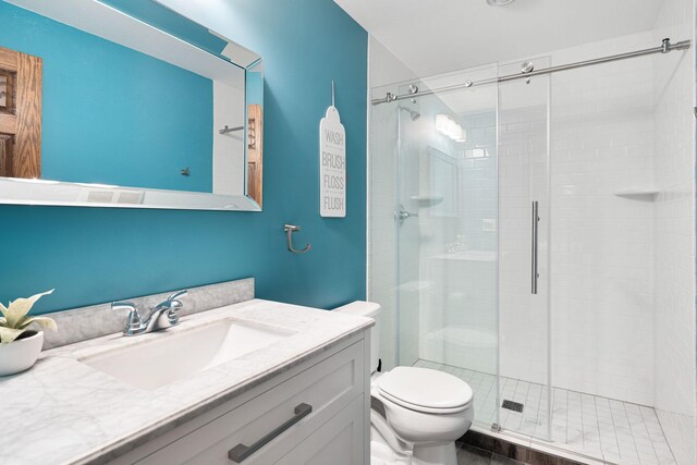 full bathroom with a shower stall, toilet, and vanity