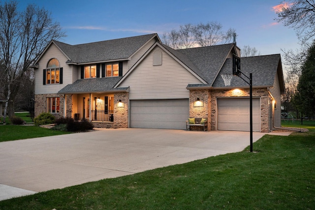 traditional home featuring brick siding, an attached garage, a porch, driveway, and a lawn