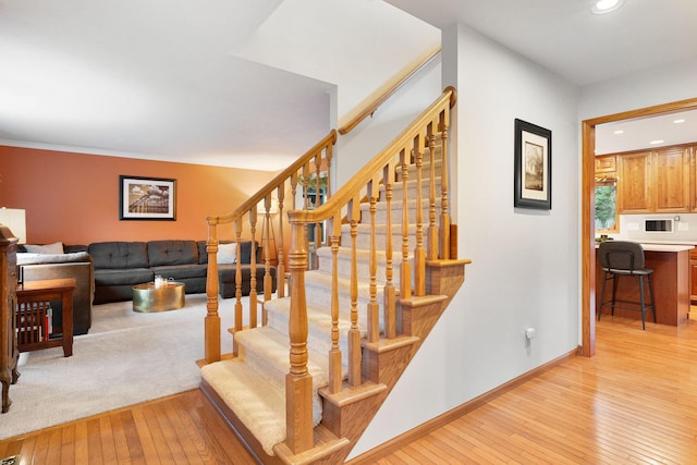 staircase featuring wood-type flooring, recessed lighting, and baseboards