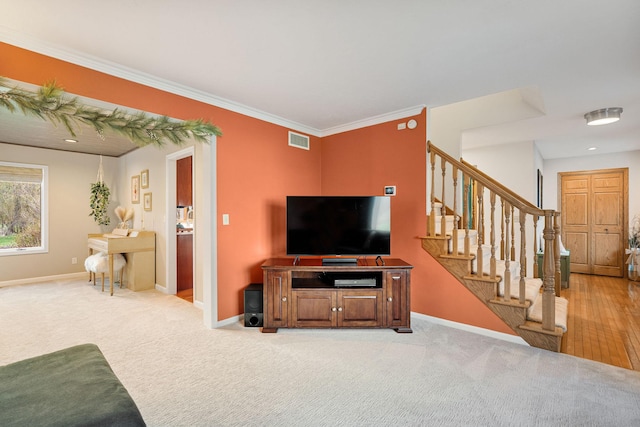 carpeted living room featuring stairway, baseboards, and crown molding