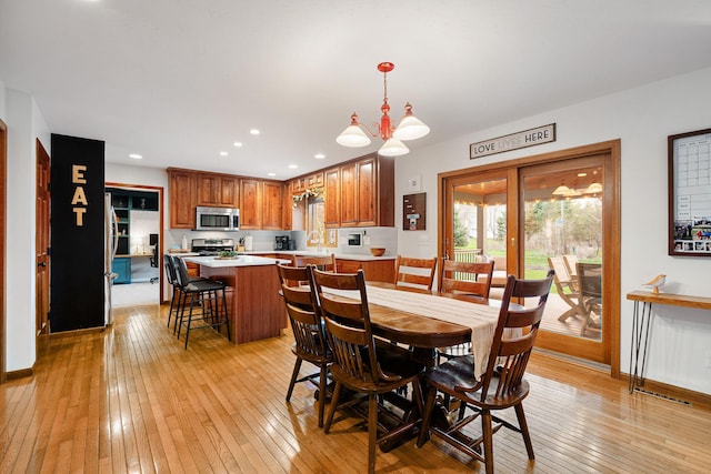 dining room featuring light wood finished floors, a chandelier, recessed lighting, and baseboards