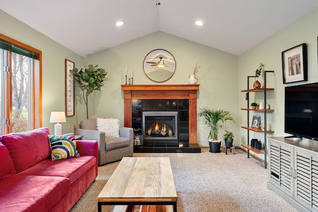 living room with carpet, a tile fireplace, vaulted ceiling, ceiling fan, and recessed lighting