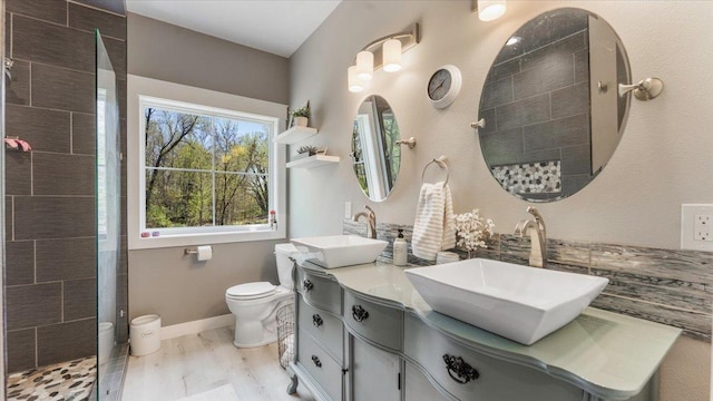 12911 Turtle Lake Ct SW, Lake Mary Twp, MN 56308 - bathroom with wood finished floors, toilet, a tile shower, double vanity, and baseboards