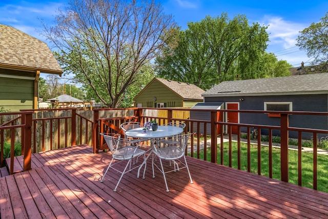 wooden deck with outdoor dining area, a shed, fence, and an outdoor structure