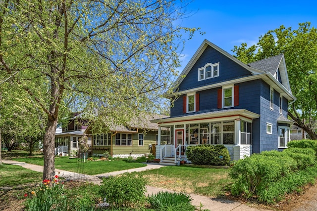 traditional style home featuring a front lawn and roof with shingles