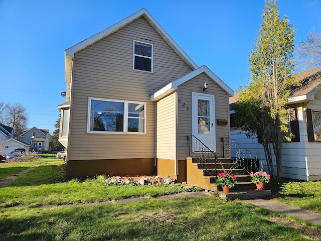 view of front of house featuring entry steps and a front lawn