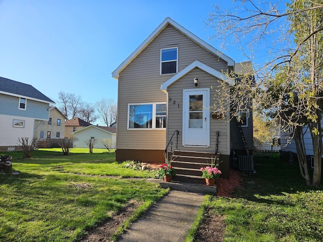 view of front of house with entry steps, a front lawn, and central AC unit