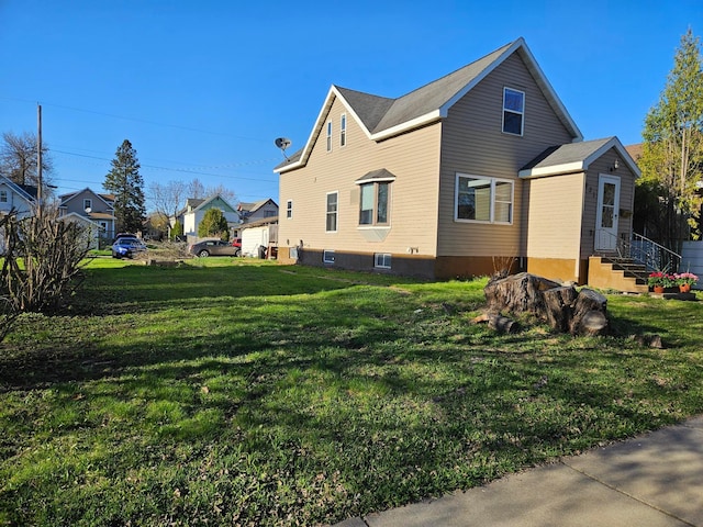 view of side of home with a lawn, central AC, and entry steps